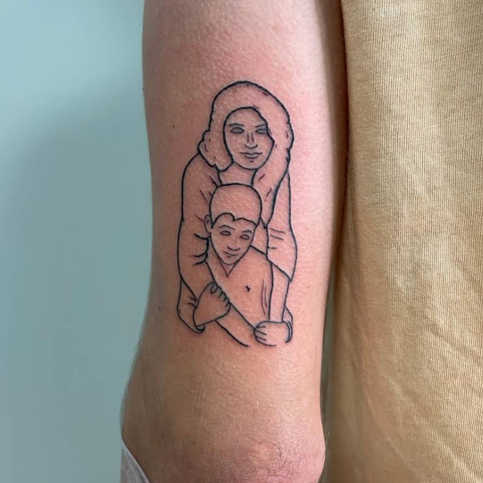 Tatuaje lineal de dos personas abrazadas, una detrás de la otra.